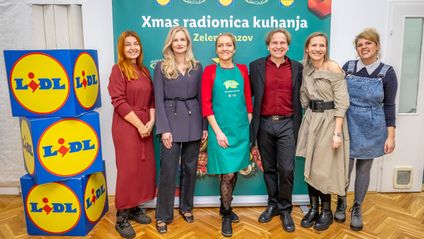 Sudionici blagdanske radionice kuhanja poziraju ispred banera Lidla i udruge Prijatelji životinja.