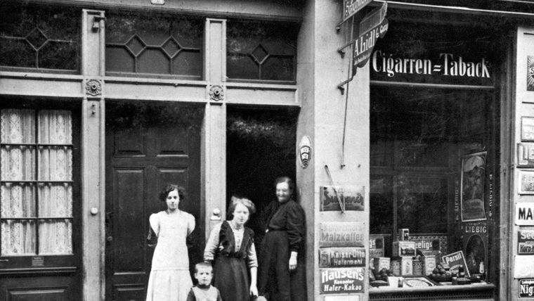 Schwarz-Weiß-Fotografie der ersten Lild Filiale mit der vierköpfigen Gründerfamilie und deren Hund.