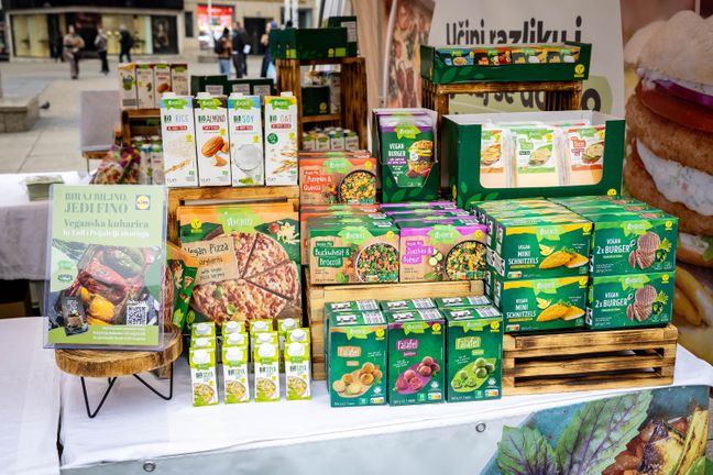 Eine bunte Vielfalt an Vemondo-Pflanzendrinks und Snacks steht auf einem Marktstand.