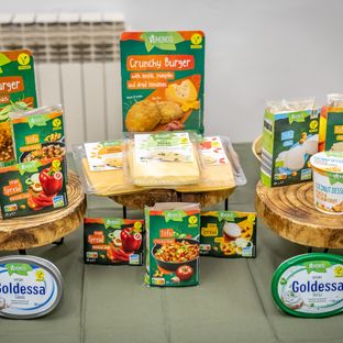 Raznoliki Vemondo veganski proizvodi, uključujući tofu, veggie burgere, namaze i biljne sireve, izloženi na drvenim postoljima.
