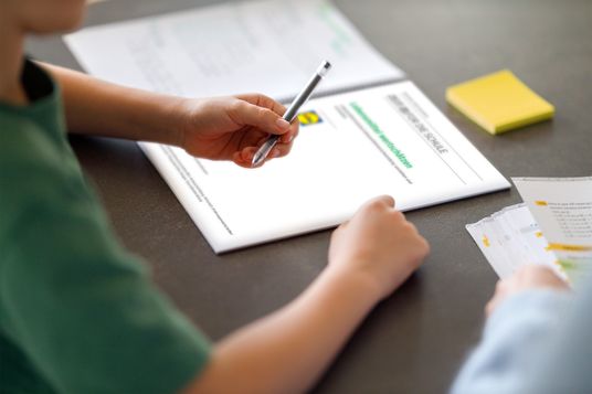 Junge hält Stift vor Lernunterlagen