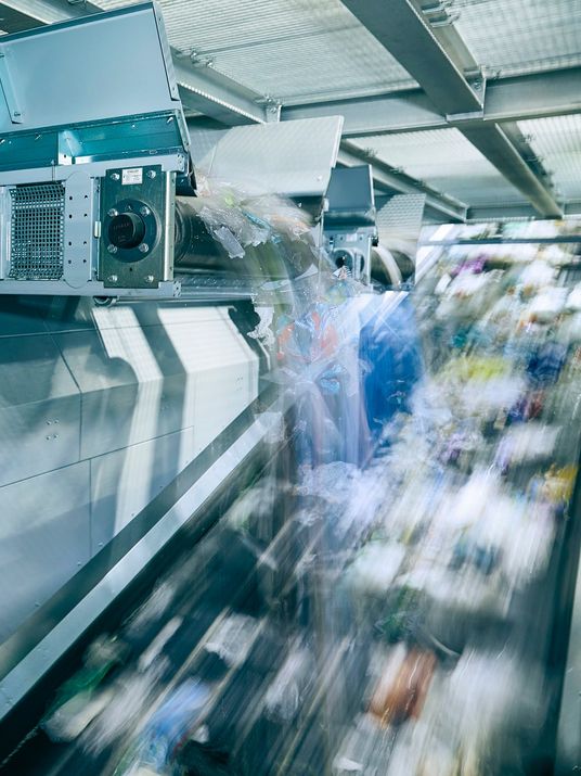 Industrielle Sortieranlage befördert gemischten Plastikabfall über Förderbänder.