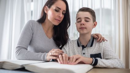 Betreuung blindes Kind beim Lesen