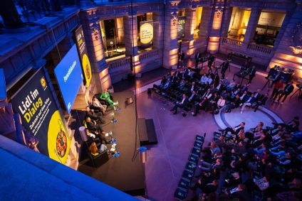 Naheinstellung von fünf Diskutanten auf der Bühne, die unter einem Banner für gesunde Ernährung gestikulierend sprechen.