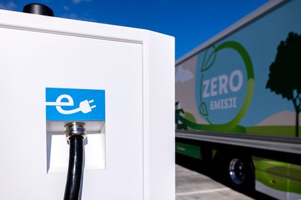 Detailaufnahme einer Grünstrom Ladesäule, im Hintergund im Anshcnitt ein Lidl Zero-Emissions-Lkw.