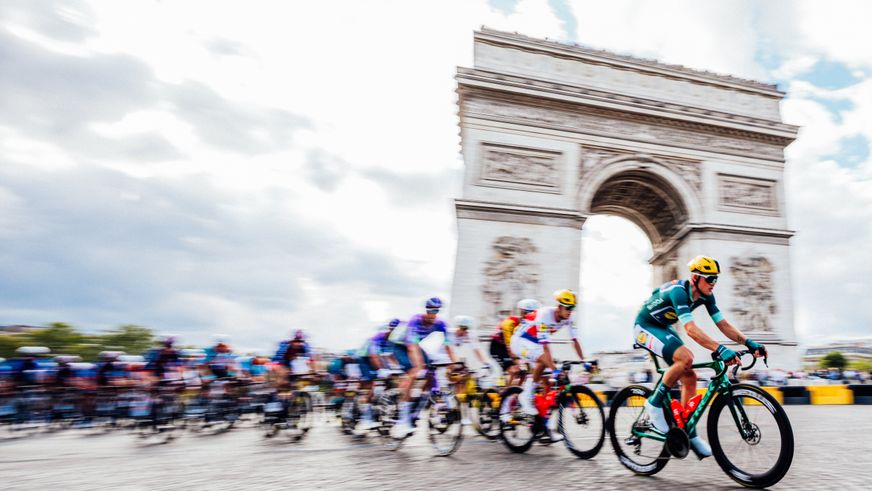 Lidl-Trek Radfahrer vor dem Arc de Triomph in Paris.