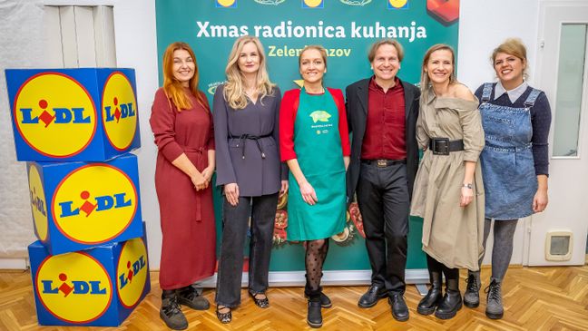 Sudionici blagdanske radionice kuhanja poziraju ispred banera Lidla i udruge Prijatelji životinja.