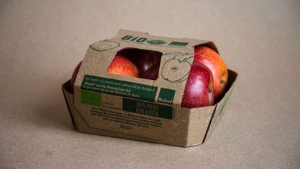 Red organic apples in plastic-free cardboard packaging.