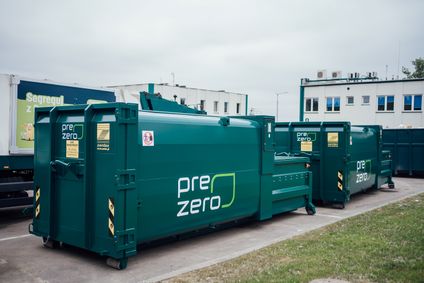 Kompakte, grüne PreZero-Presscontainer zur effizienten Abfallentsorgung stehen auf einem Betriebsgelände.