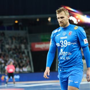 Hrvatski rukometni reprezentativac David Mandić u plavom dresu hoda po terenu tijekom utakmice.