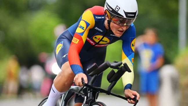 Seitliche Nahaufnahme einer konzentrierten Lidl-Trek Radsportlerin in tiefer Aero-Position mit Helm und verspiegeltem Visier.