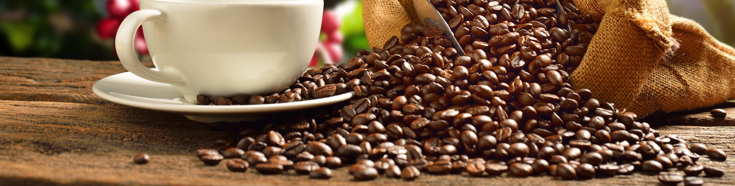 Cup of coffee with smoke and coffee beans in burlap sack on coff