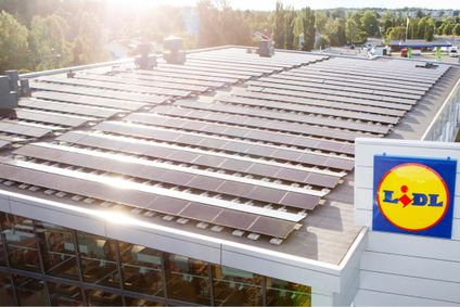 Net Zero Strategie im Handel: Großflächige Photovoltaik-Anlage auf dem Dach einer modernen Lidl-Filiale bei Sonnenlicht.