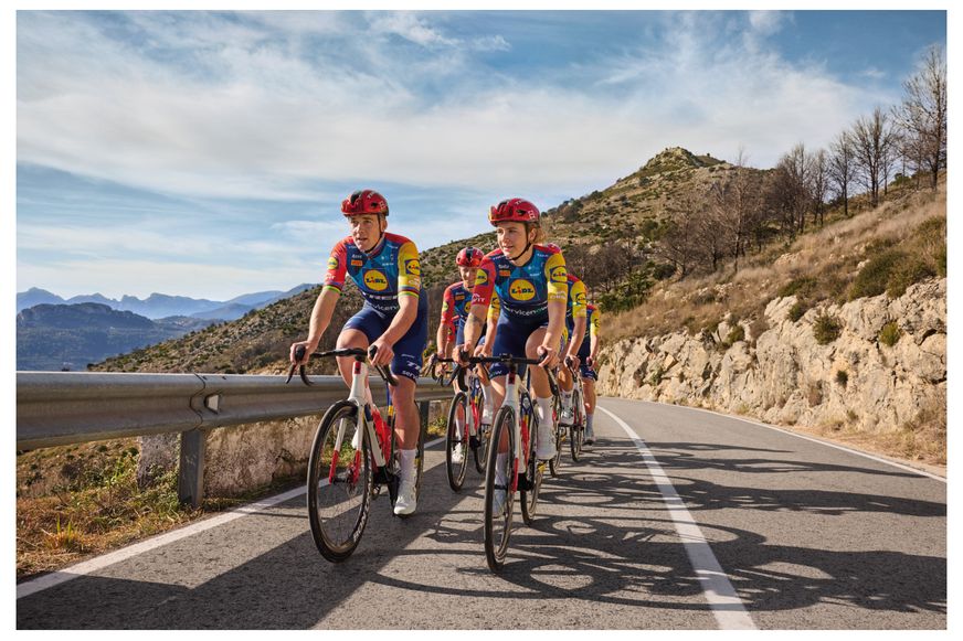 Eine Gruppe von Radrennfahrern im Lidl-Trek-Trikot fährt hintereinander eine kurvige Bergstraße hinauf.