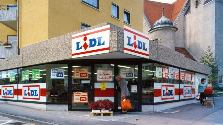 Aufnahme der Außenfassade des ersten Lidl-Marktes mit Retrologos und handgeschriebenen Preisschildern.