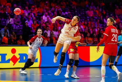 Eine polnische Nationalspielerin setzt vor vollbesetzten Zuschauerrängen zum Sprungwurf an.