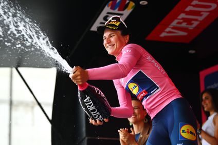 Die Siegerin, Elisa Longo Borghini, des Giro d'Italia Women verspritzt jubelnd Champagner auf dem Podium.