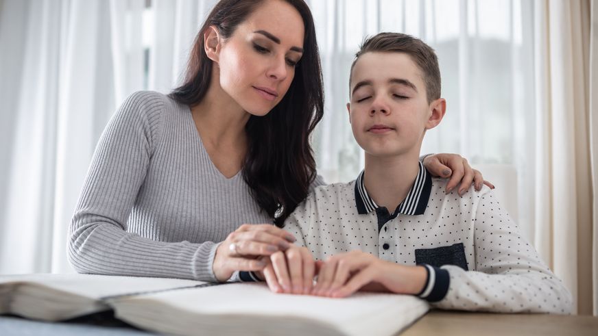 Betreuung blindes Kind beim Lesen
