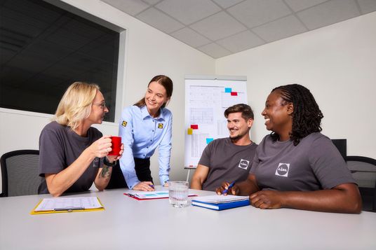 Lächelnde Kollegen in einem Meeting.