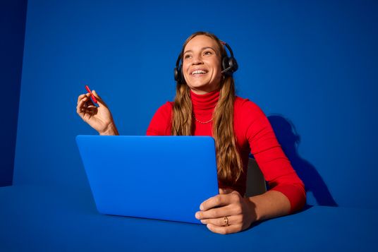 Lidl-Kollegin mit Headset vor einem blauen Laptop